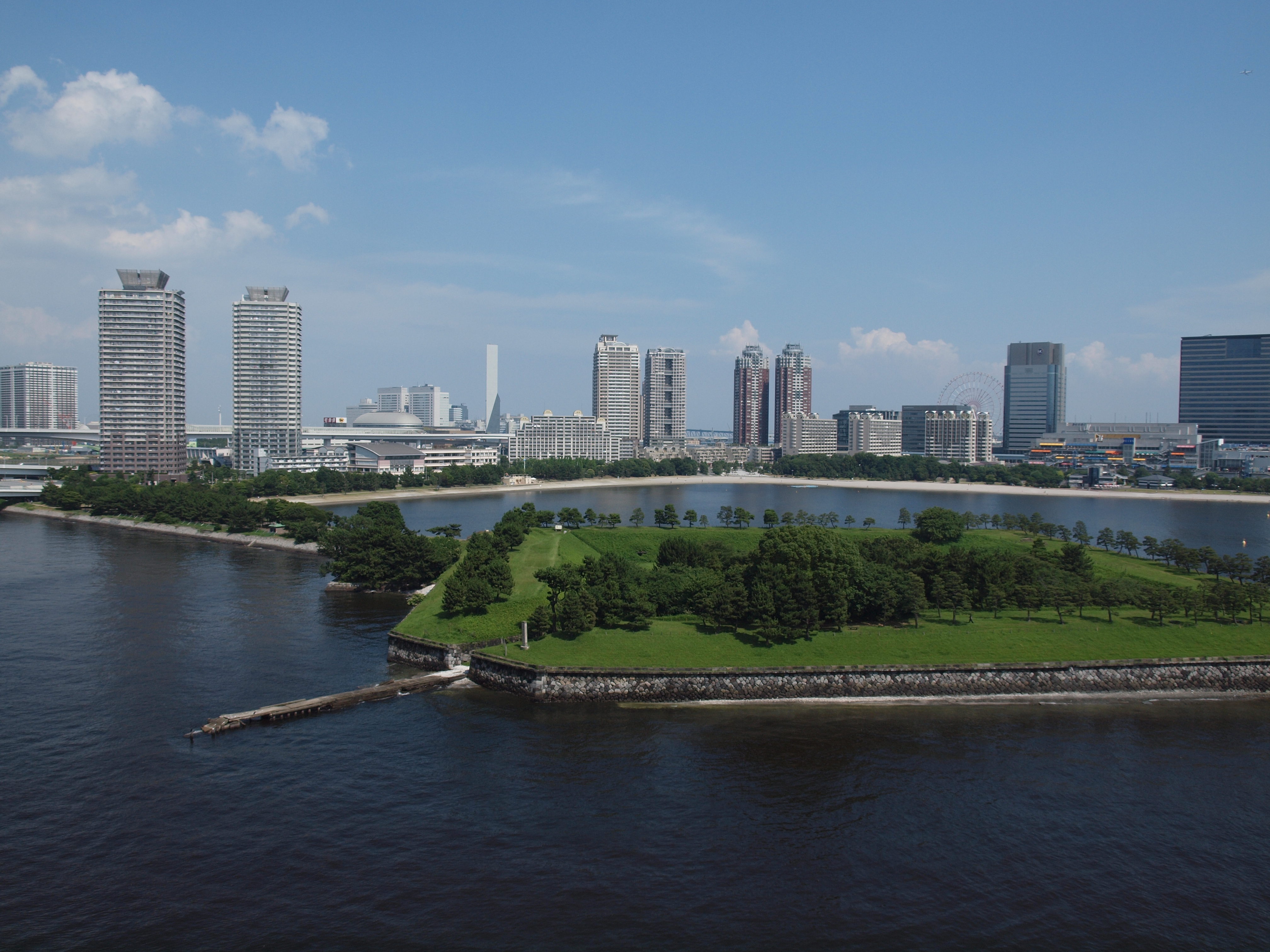 <b>橋から見た台場公園。奥手のお台場海浜公園は平日なので、人影は少ない。昔のオリンパスはもっと空が青かったんだよなぁ、と思う<br>4,032×3,024 / ZUIKO DIGITAL ED 14-42mm F3.5-5.6 / 1/640秒 / F8 / -0.3EV / ISO200 / WB：晴天 / 14mm</b>