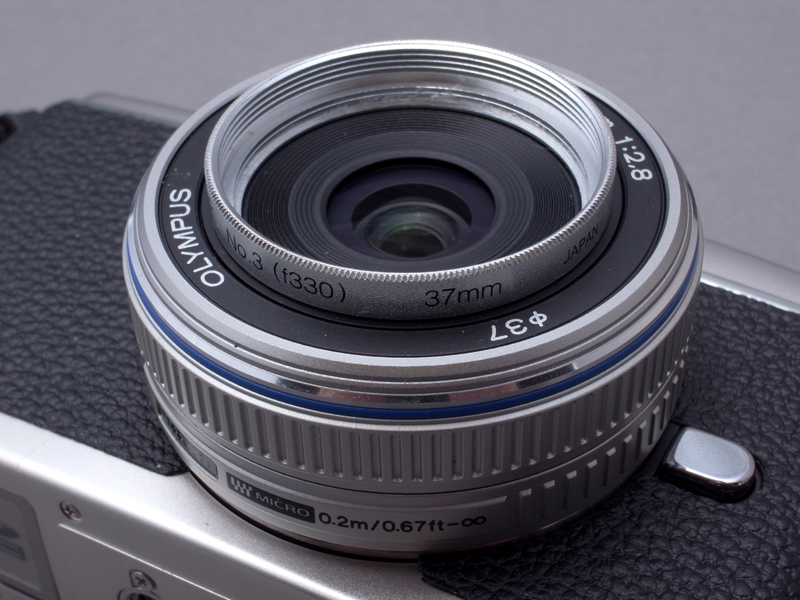 <b>DW-4とGW-1は取り付けネジ径37mmなので、同じ37mmネジ径を持つM.ZUIKO DIGITAL 17㎜ F2.8に簡単に装着できそうである。しかしM.ZUIKO DIGITAL 17㎜ F2.8はパンケーキレンズのためか、フィルターのねじ込み部が浅く、ワイコンを完全に装着することはできない。そこで、37mm径のフィルターのガラスを抜いた枠パーツを、まずレンズにねじ込む。こうすると、ワイコンをレンズにしっかり装着することができる</b>