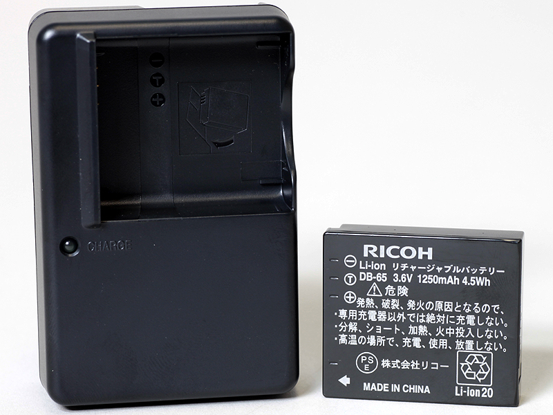 <b>付属の充電器（左）とバッテリー（DB-65、右）</b>
