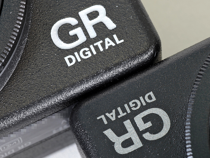<b>機種名ロゴ比較。GR DIGITAL III（奥）とGR DIGITAL II（手前）。GR DIGITAL IIは、プリントだった。色もグレーからホワイトに変更されている</b>