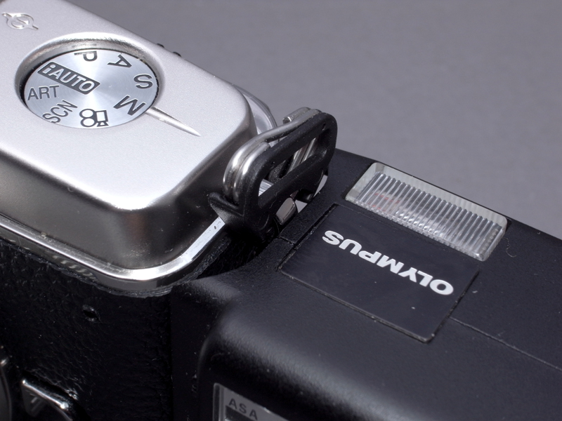 <b>A11をE-P1に接続する上で、まず気になってしまったのがこの部分。E-P1のストラップ取付金具がA11のボディの一部に干渉し、ぴったり装着できないのだ</b>