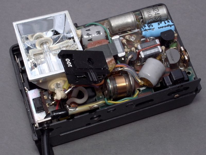 <b>新たにハンダ付けしたシンクロコードを、上手く本体内に収めながら、各パーツをネジ止めする</b>