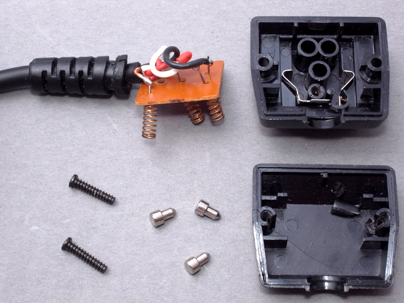 <b>オフカメラシューのホットシューを分解するところ。経年変化でネジ止め部分が割れてしまっているが、加工してしまうので問題ない。このうち、ボディ下部パーツと、内部の電気パーツのみ使用する</b>