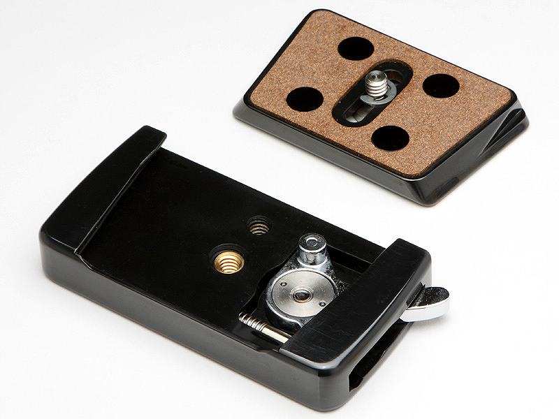 <STRONG>クイックシュー「SG-80」（手前）とシュープレート（奥）。シュープレートは上から見ると台形になっており、確実にシュー本体に固定される構造となっている。プレートのカメラと接する部分はコルクが貼られ、カメラ底部へのダメージを軽減する。また、カメラとのガタツキを防止する特許技術「剛性体」（4つの黒丸）も備えている</STRONG>