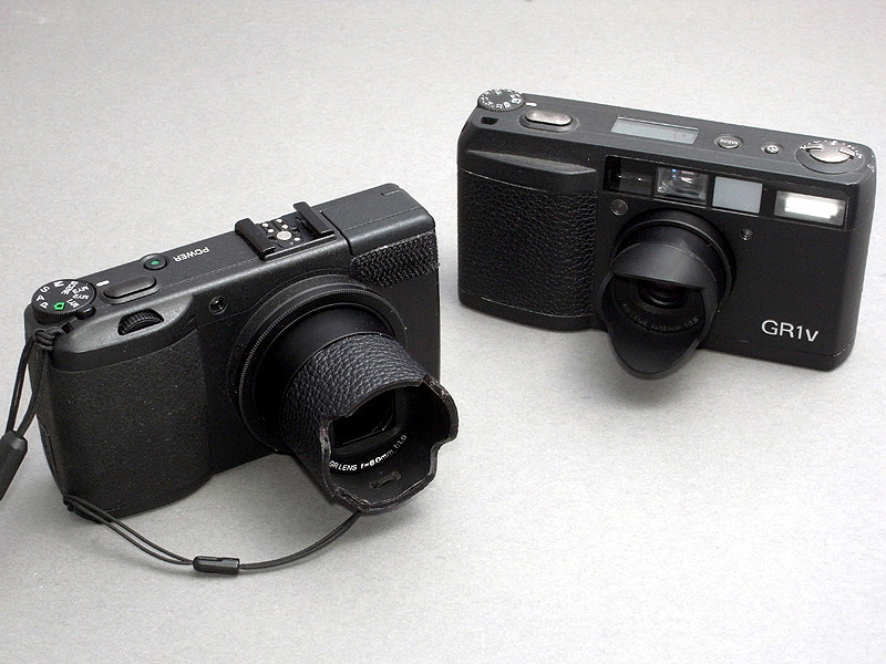 <b>自作フード付きのGR DIGITAL IIIと、フィルムカメラのGR1vを並べてみたが、あらためて全く違うカメラであることがわかる。GR1vはフィルムコンパクトカメラの完成形であり、GR DIGITAL IIIはコンパクトデジタルカメラの完成系を目指している</b>