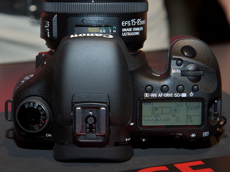 <b>上面。モードダイヤルはEOS 50Dのシルバーと異なり黒色。メイン電子ダイヤル脇のM-Fnボタンも新機能</b>
