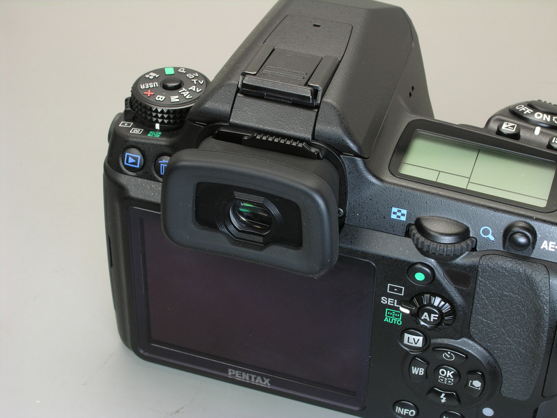 <b>K-7のファインダー倍率は0.92倍。K20Dの0.95倍に比べると倍率が低いが、視野率が高いので、実際にファインダーを覗いたときの視野はK-7の方が広く見える。試しに拡大アイカップO-ME53を取り付けてみたが、アイピースにぴったり眼を押し当てないと四隅がけられてしまう。結論として、何も付けない方がよいようだ</b>