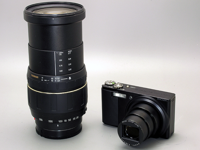 <b>左はフィルムカメラ時代に高倍率ズームレンズとして一世を風靡したタムロン28～300mmズーム。CX2はコンパクトなボディに、このレンズと同じ画角のズームレンズを内蔵している</b>