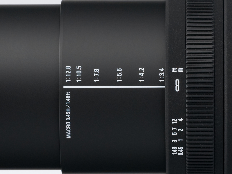 <b>最短撮影距離は0.45m。鏡胴には各焦点距離における最短撮影距離での撮影倍率が印刷されており、近接撮影時の目安にできる</b>