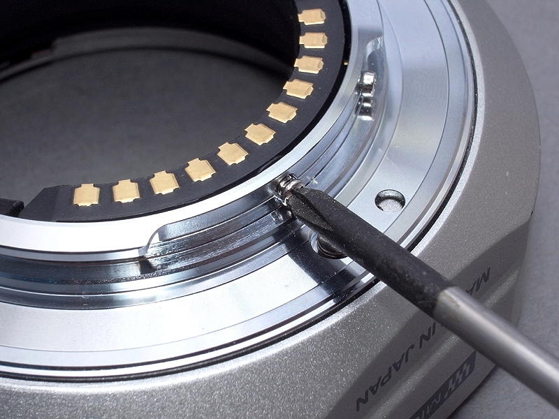 <b>まずは電子接点パーツをマウントに固定している小ネジを外す。その次にマウントを止める4本のネジを外す</b>