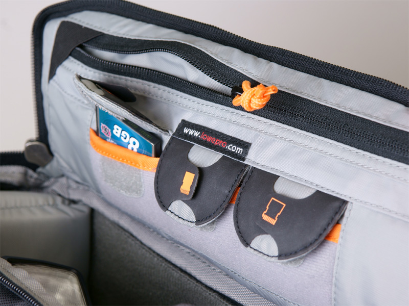 <b>側面のフラップ。3つのメディア用ポケットはCFまで対応。使用済みメディアを区別するタブもついている。マチのないポケットも備える</b>