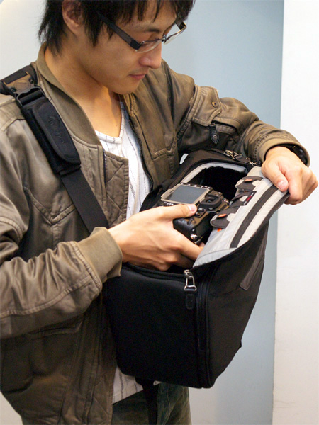 <b>機材を取り出すところ。体の正面でバッグがしっかり止まるため、不安がない</b>