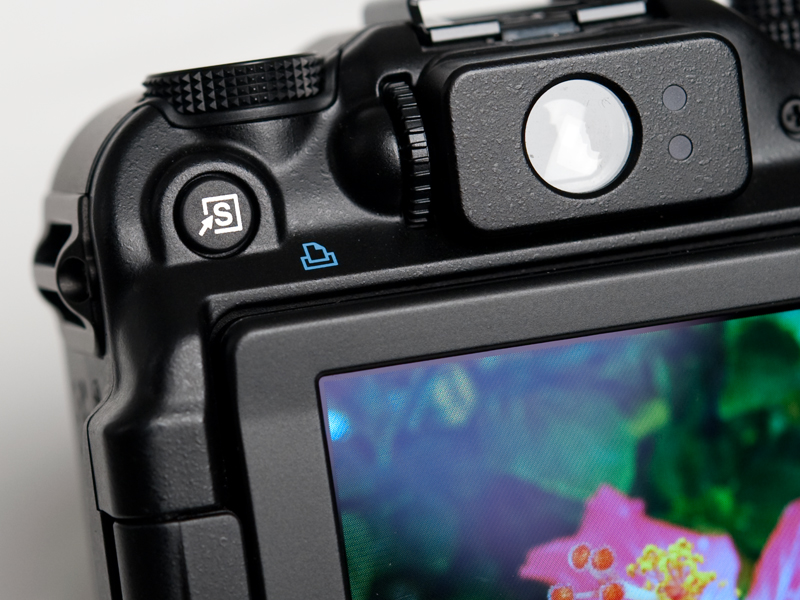 <b>ボディ左側に設けられたショートカットボタンには、特定の機能を割り当てることができる。割り当てられる機能は、NDフィルター、ホワイトバランス、マニュアルホワイトバランス1、同2、サーボAF、デジタルテレコン、赤目自動補正、i-コントラスト、AFロック、ディスプレイオフのいずれか1つ</b>