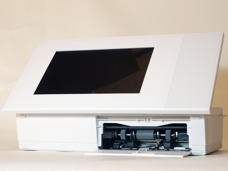 <b>DPP-F700。立てた状態で底面に位置する部分には、ペーパートレイの挿入口がある。プリンターを利用するときには一度本体を寝かせてトレイを差し込む必要がある</b>