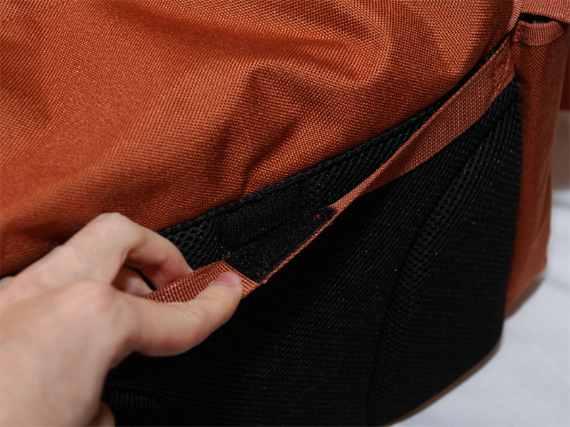 <b>背面にはスーツケースのハンドルを通す部分。中央にベルクロで固定されている</b>