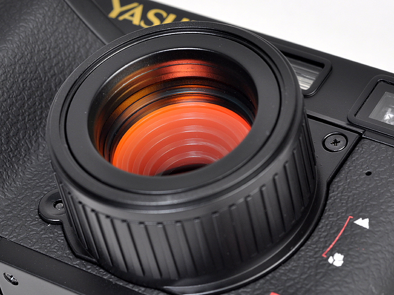 <b>大きめの鏡胴は回転させることでマクロモードに切替えることができる。前玉はマゼンタ色のコートが施してある</b>