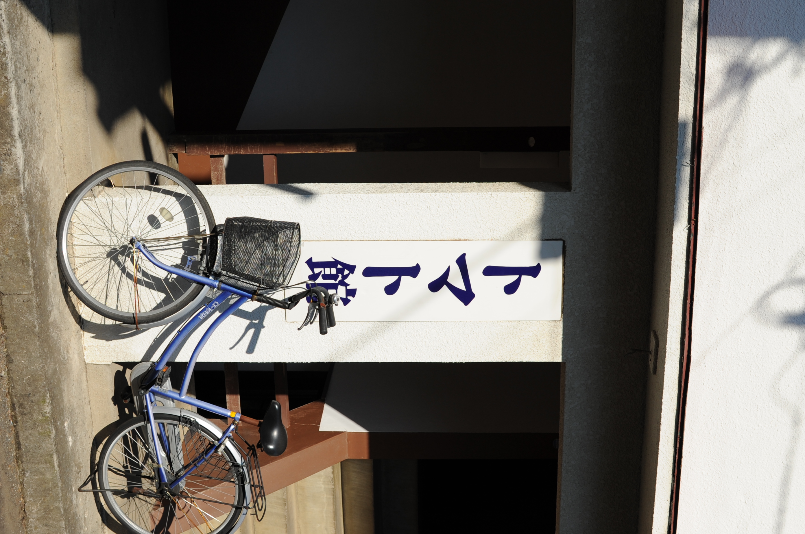 <b>かなり思い切ったネーミングの古いアパート。傾斜地に建っていて、玄関は1階と2階の中間の、階段の踊り場的な位置なのが面白い<br>D700 / AF-S DX NIKKOR 35mm F1.8 G / 2,784×1,848 / 1/1000秒 / F5.6 / +0.7EV / ISO200 / WB:太陽光 / 35mm（52.5mm相当）</b>