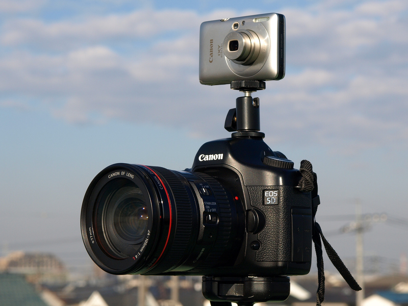 <b>上段に動画用のIXY DIGITAL 210 IS、下段に静止画用のEOS 5Dという組み合わせ。2台をつなぎ止めているのがボールヘッドシューのE-6116だ。価格は2,625円</b>