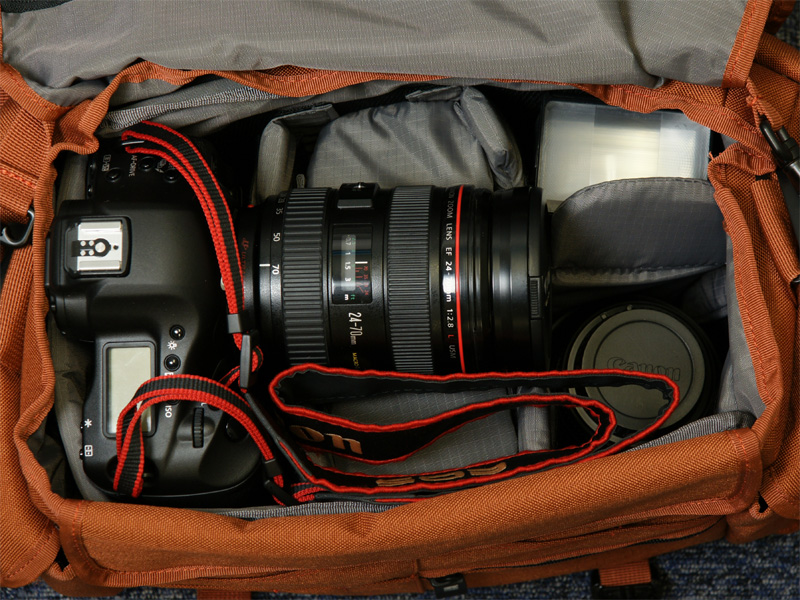 <b>EF 24-70mm F2.8 L USMを装着したEOS-1D Mark IV、EF 100mm F2.8 L Macro IS USM（フード付き）、サンパックのクリップオンストロボを収納。まだ大きくスペースが余っている</b>