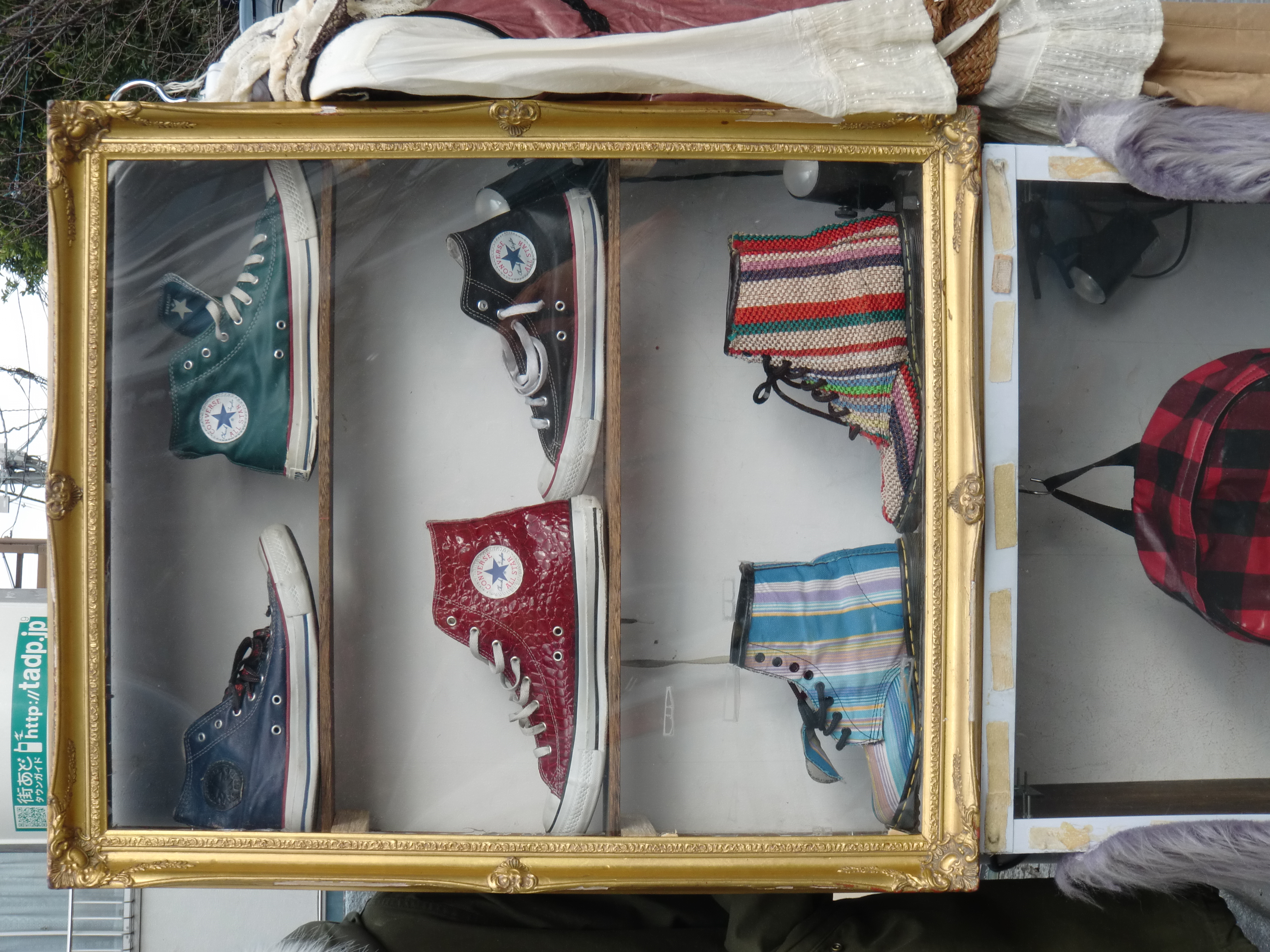 <b>額縁みたいな意匠のショーケース。この画角でもタル型の歪曲収差がちょっと残っている。下の段のもスニーカー……なのか?<br>EX-G1 / 4,000×3,000 / 1/100秒 / F4.8 / 0EV / ISO64 / WB:太陽光 / 13.9mm（79mm相当）</b>