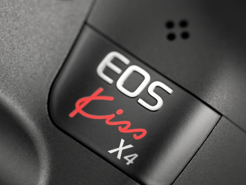 <b>前モデルまでは「EOS」と「Kiss」が別々の場所だったのが、本機では1か所にまとめられた。その上の穴は内蔵マイク</b>