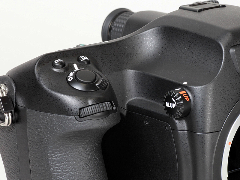 <b>上部のえぐれの意匠が、シャッターボタン側まで続く</b>