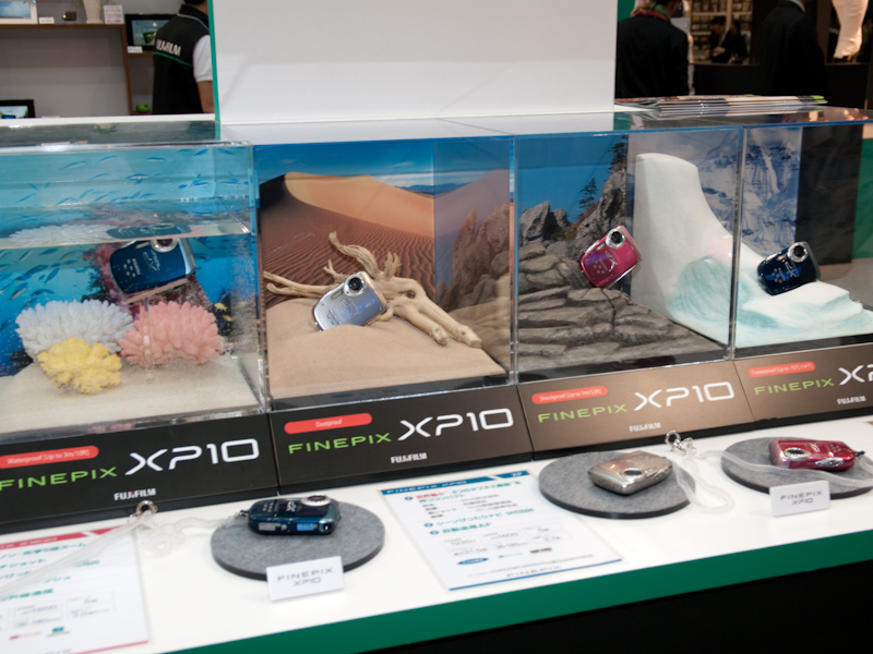<b>FinePix XP10の耐性デモ。左から防水、防塵、耐衝撃、耐寒</b>