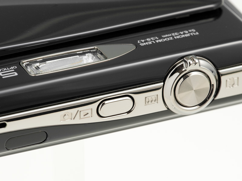 <b>操作パーツはシャッターボタンとその外周のズームレバーのほかは、撮影と再生を切り替える撮影/再生ボタンぐらい。画面左端は赤外線通信用の窓</b>