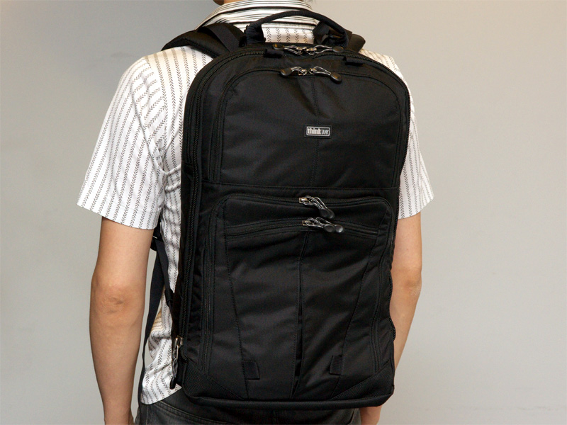 <b>カメラ機材を抜き、マチを畳んだ状態の着用例。厚さが半分以下になる</b>