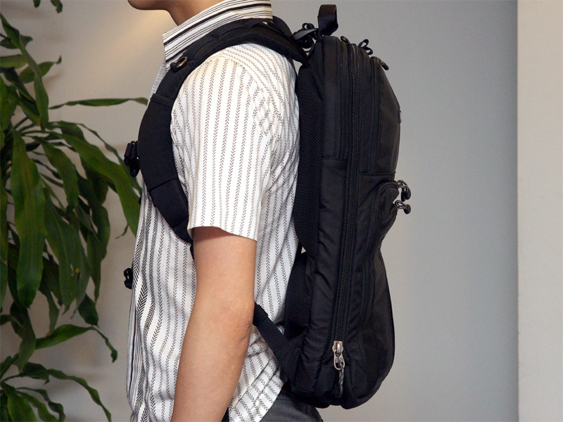 <b>カメラ機材を抜き、マチを畳んだ状態の着用例。厚さが半分以下になる</b>