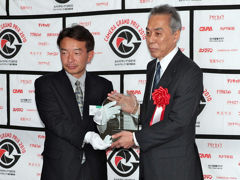 <b>カメラグランプリ大賞の盾を受け取るオリンパスイメージング代表取締役社長の大久保雅治氏（右）</b>