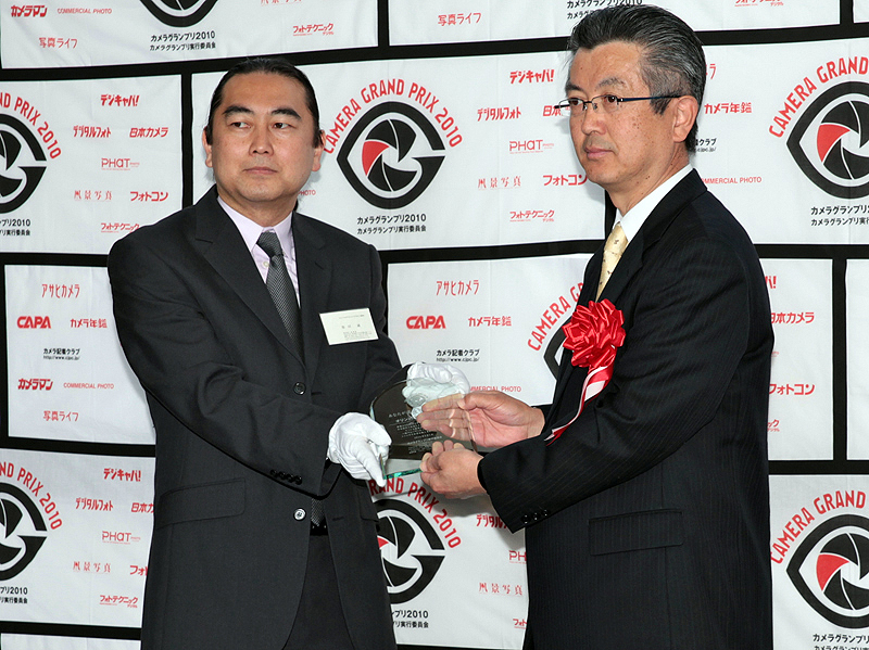 <b>あなたが選ぶベストカメラ大賞の盾を受け取るオリンパスイメージング取締役 国内営業本部長の五味俊明氏（右）</b>