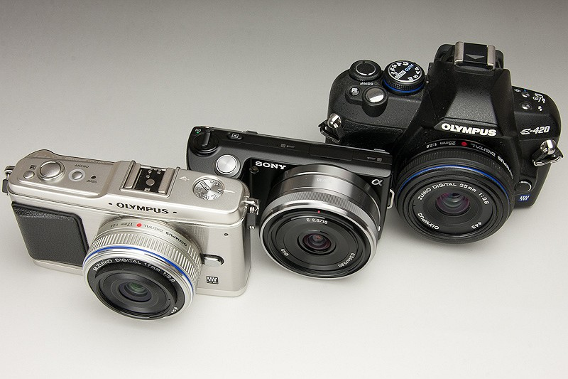 <b>左からE-P1、NEX-5、E-420。フォーサーズサイズでファインダーも備えたE-420はともかく、E-P1よりも大幅に小さいのが驚き。これでAPS-Cサイズの撮像素子を搭載しているとは驚きだ。ただ見ての通り、最も広角であることを差し引いても、レンズサイズはE-420のパンケーキレンズ並みに大きい</b>