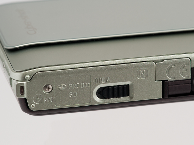 <b>黒いロックレバーを画面左方向にスライドさせるとスプリングの力でカバーが跳ね上がる仕組み。7機種中でもっともシンプルな方式だ</b>