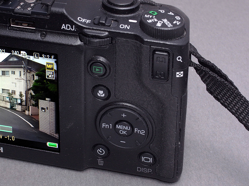 <b>GXRの背面の操作ボタン類もカスタム可能で、ぼくは十字キーの「Fn1」ボタンに「AF/MF」切り替えを登録している。普段の撮影はMFで行ない、中距離撮影時などワンタッチでAFに切り替えることができる。AFスピードは、マクロ以外の通常撮影ではそれほど遅いとは感じない。露出補正は十字キーの「+/-」で行い、ISO感度とWB変更は「ADJ.」ボタンで行なう。これら機能の割り当ては、さまざまに変更できる</b>