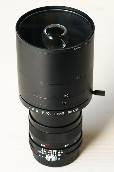 <b>玉の周囲を透明にするという方式に可能性を感じ、お金をかけて作ったのがこのレンズ。「K.P.S. PRO. LENS SHADE」を使って、コシナのディスタゴン T* 2.8/25に取り付けた。最短撮影距離を短くするために接写リングを使ってカメラボディに取り付ける</b>