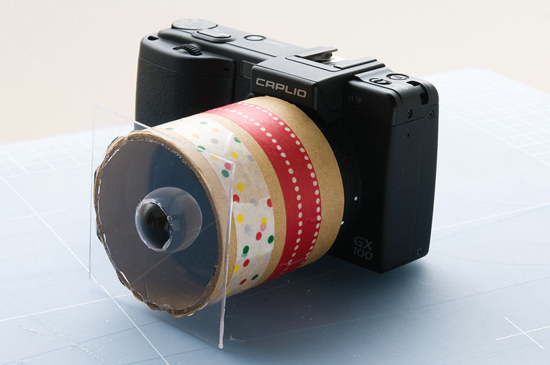 <b>アクリル板に穴を空け、透明球と接着。紙筒とアクリル板も接着剤で貼り付けただけの簡単工作。撮影時にはマニュアルでピントを合わせる。だいたい2cmぐらいの所でピントが合う</b>