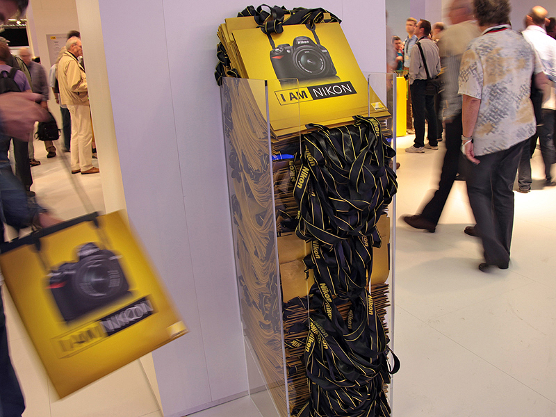 <b>ブースでは、カメラのストラップをイメージした取っ手の紙袋を配布しており人気だった</b>