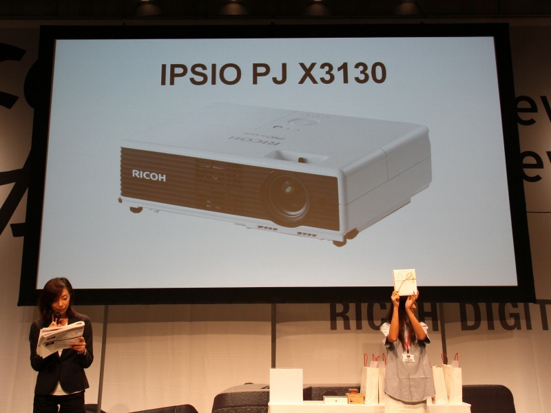 <b>金賞はリコーのプロジェクター。発売前のため目録を手渡す</b>