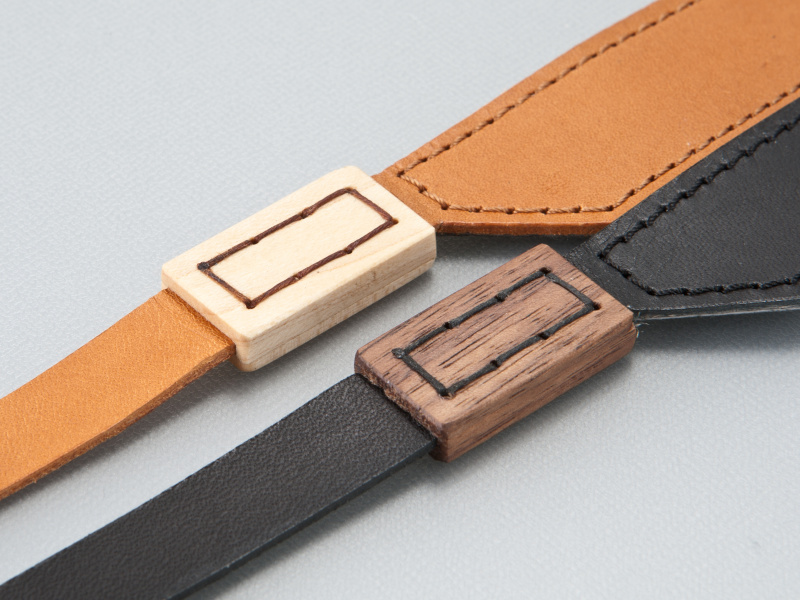 <b>天然木の種類はカラーによって異なる。茶はメープル、黒はウォールナットが縫いつけてある</b>