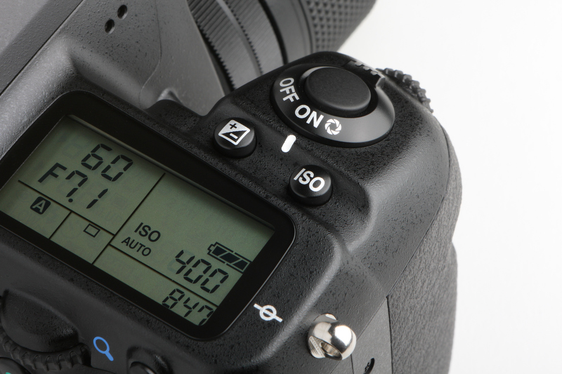<b>シャッターボタンと液晶パネルの間には、露出補正ボタンとISOボタンが並ぶ。慣れの問題かも知れないが、カメラを構えて露出補正を行なうとISOボタンを押してしまうことがあった</b>