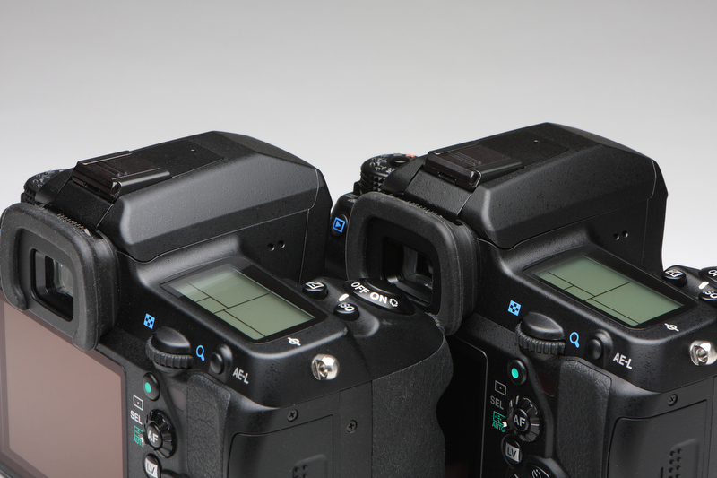 <b>K-7（左）との外観上の違いは、撮影モードダイヤルの高さとAFモード切り換えレバーの形状のほか、写真のペンタ部のエッジだけだ。K-7はエッジが緩いカーブとなるが、K-5はエッジの角が立っている</b>