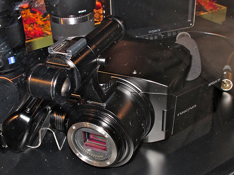 <b>上部にハンドルを備える。また、本体上面の2つの穴を利用して別売の小型液晶モニター（右奥）を装着できるという。本体の左奥にあるのは着脱式のグリップ</b>