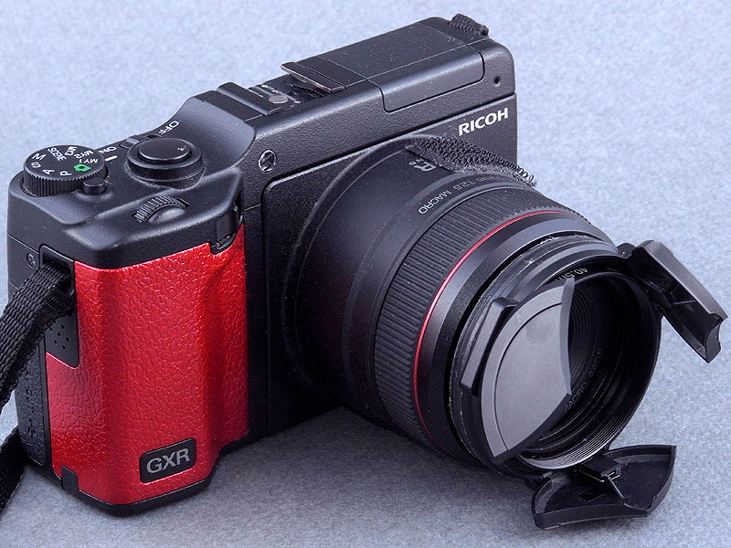 <b>塗装したゴムを、元通りグリップに貼り付けると完成! レンズ鏡筒リングのメタリックレッドとコーディネートしてみたのだが、なかなか似合っている。ゴムにメタリックカラーは素材としても違和感があるかも知れないが、イマドキはこれくらいの派手さが無いとオリジナルカラーとしては主張できない（笑）</b>