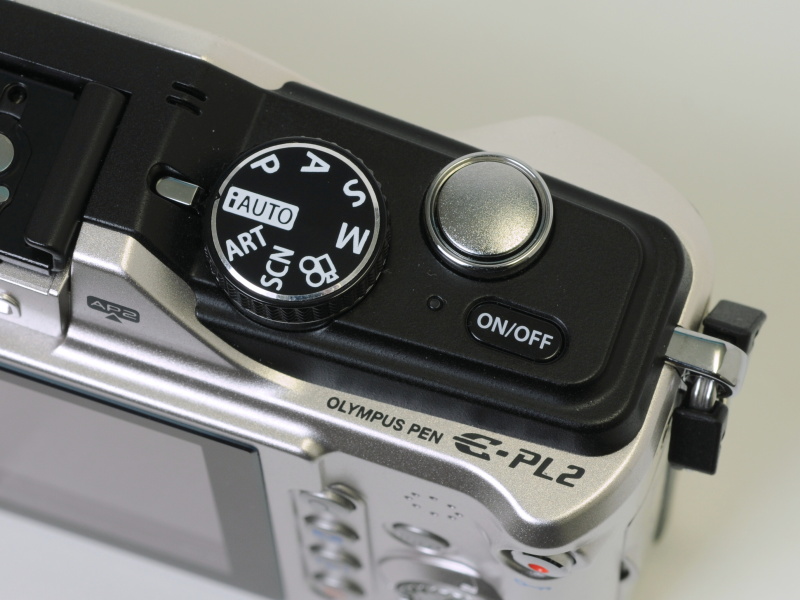 <b>上部右手側の操作部。E-PL1sと同様、電源ボタンとモードダイヤルを右側に配置した</b>