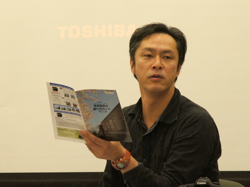 <b>鉄道写真家の広田泉氏。自身が撮影した撮り方ガイド冊子を手に、撮影の心得などを解説</b>