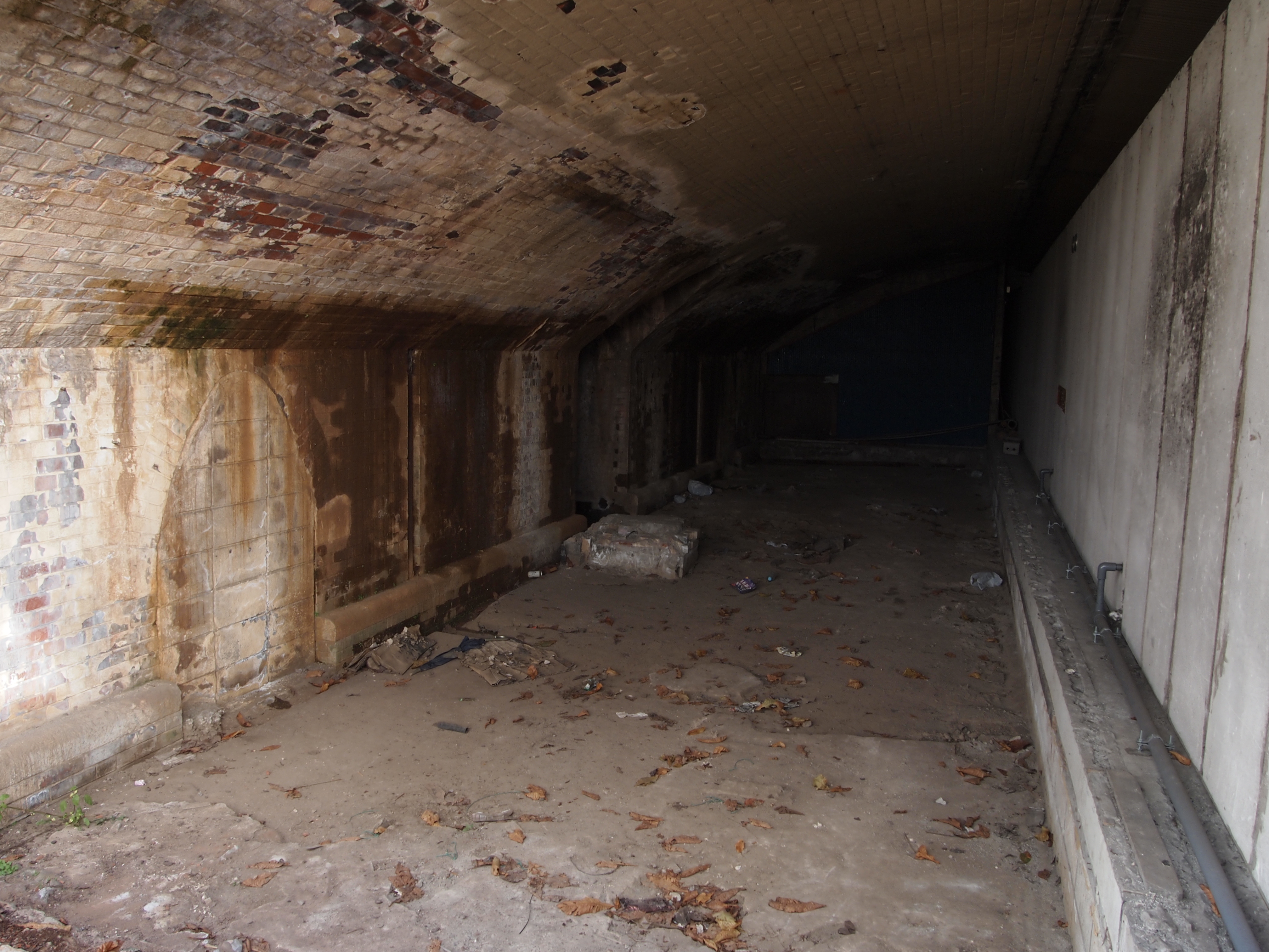 <b>JRの高架下の空間は飲食店が入居していたりするが、ここは空き家。工事用のフェンスの上に手を伸ばして撮ったカット<br>E-PL2 / M.ZUIKO DIGITAL 14-42mm F3.5-5.6 II / 4,032×3,024 / 1/30秒 / F5.6 / -1.3EV / ISO200 / WB:オート / 14mm</b>