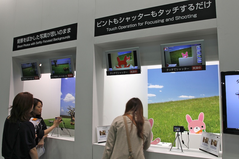 <b>飛び出す動物をタッチフォーカス・タッチシャッターで撮影するデモ。奥ではタッチ操作により背景をぼかした撮影を体験できる</b>