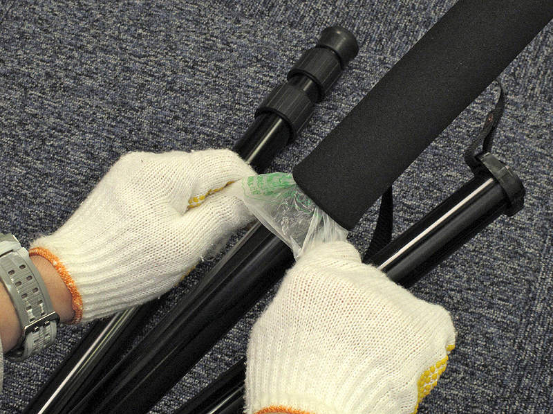 <b>先ほど用意したグリップを三脚のパイプに滑らせていく。このとき買い物袋をつまんで引くと良い</b>