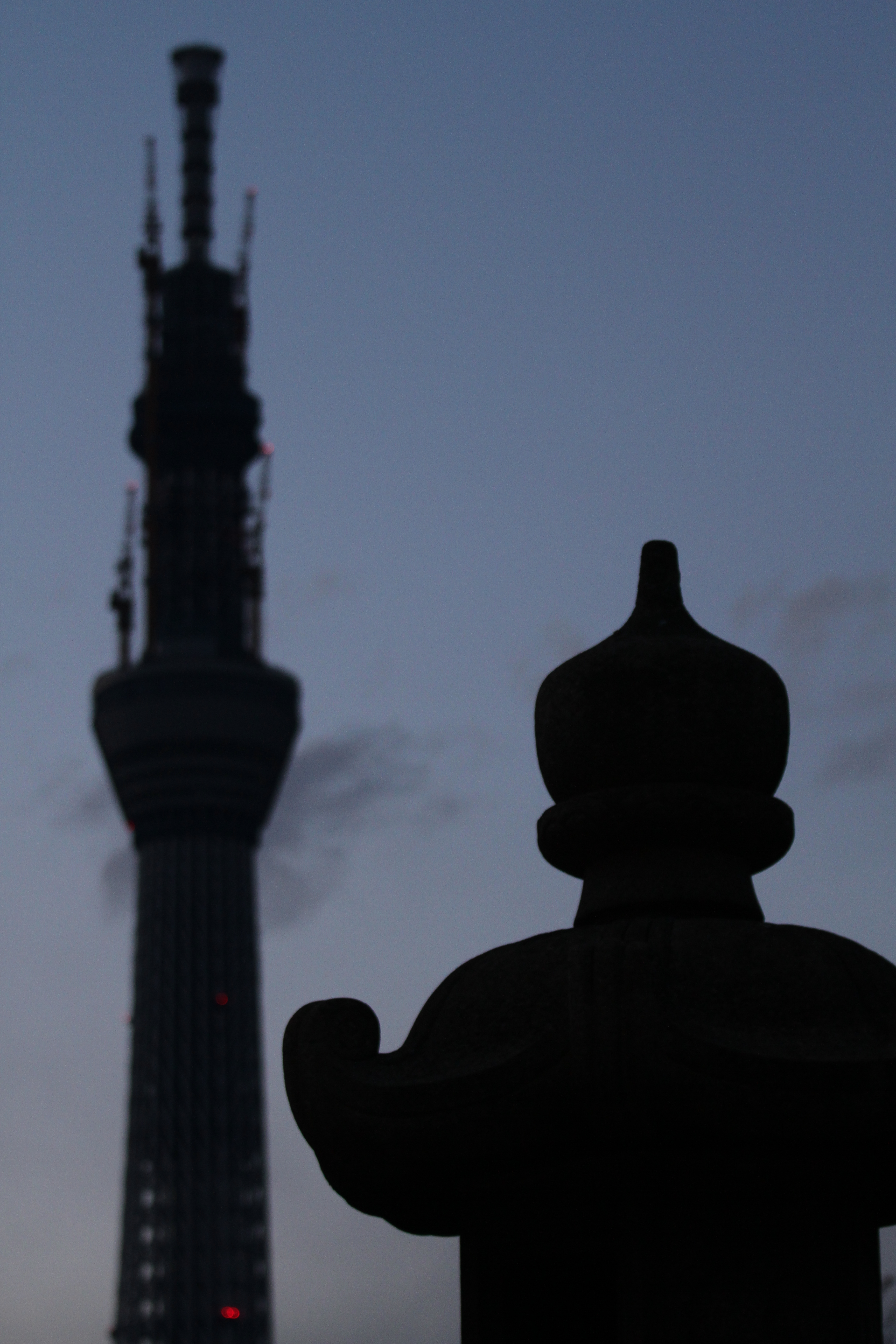 <b>境内の灯篭と東京スカイツリー。なるべくシンプルな写真を狙った。EOS 7D / EF 70-200mm F4 L IS USM / 3,456×5,184 / 1/60秒 / F4 / -1.3EV / ISO800 / プログラム / WB:オート / 78mm / 17:21</b>